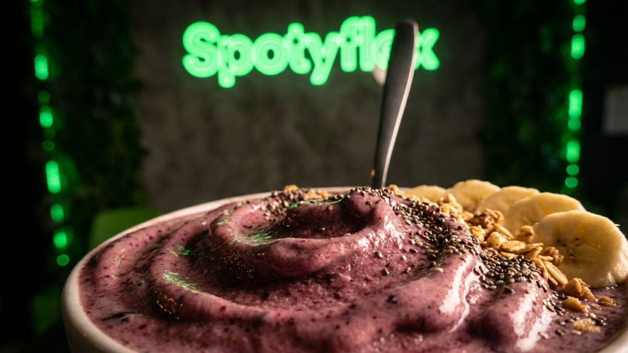 Blender with frozen fruit making a thick smoothie bowl base